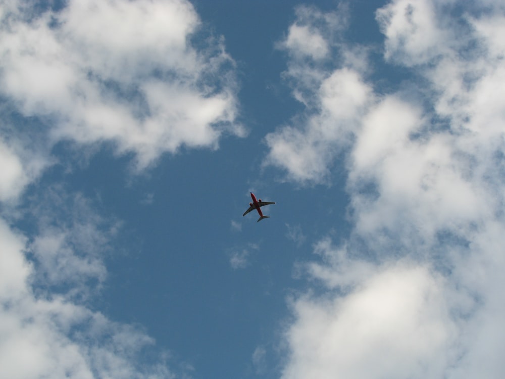 black and red airplane under blue and white skies