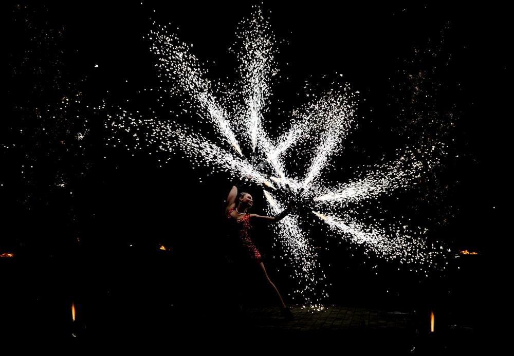 woman dancing with fire crackers at nighttime