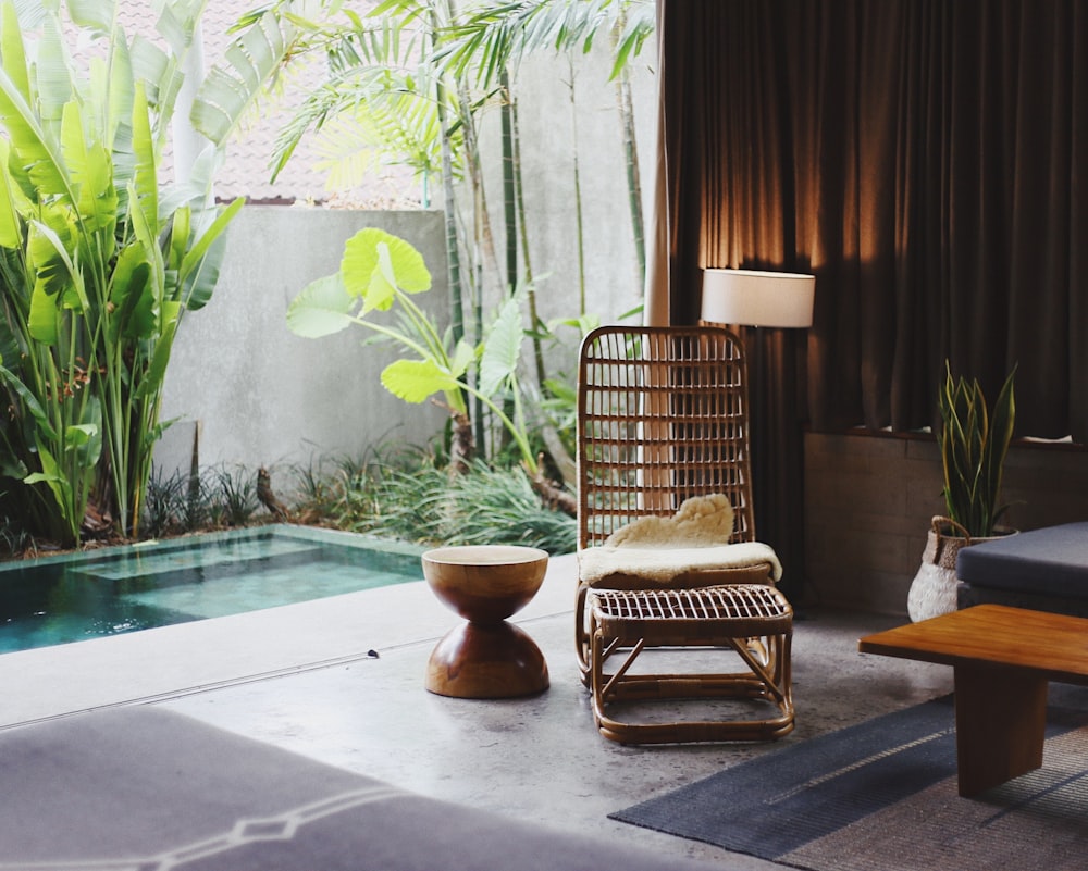 brown wooden chair and stool beside swimming pool