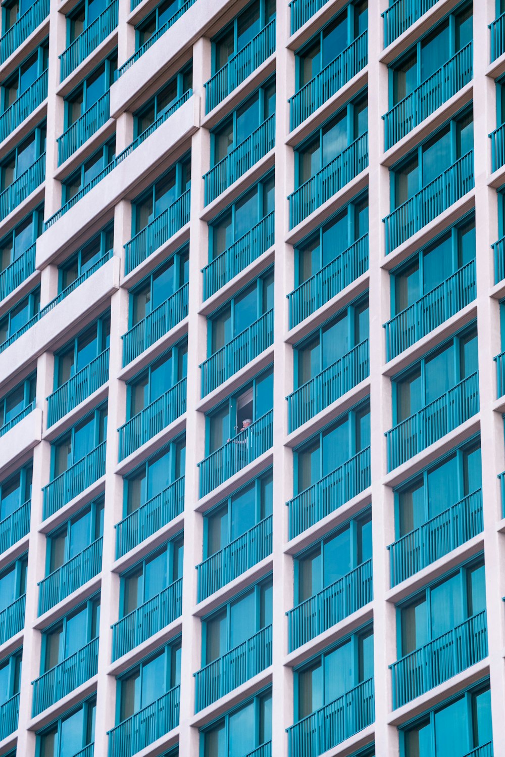 テラス付きの白と青のコンクリートの高層ビル