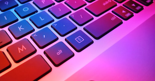 a close up of a laptop keyboard with red and blue keys