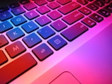 a close up of a laptop keyboard with red and blue keys
