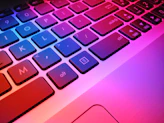 a close up of a laptop keyboard with red and blue keys