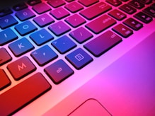 a close up of a laptop keyboard with red and blue keys