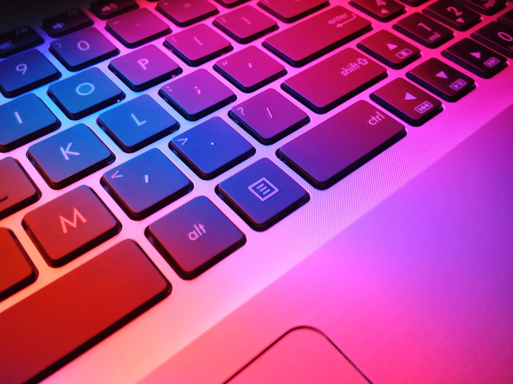 Um close up de um teclado de laptop com teclas vermelhas e azuis
