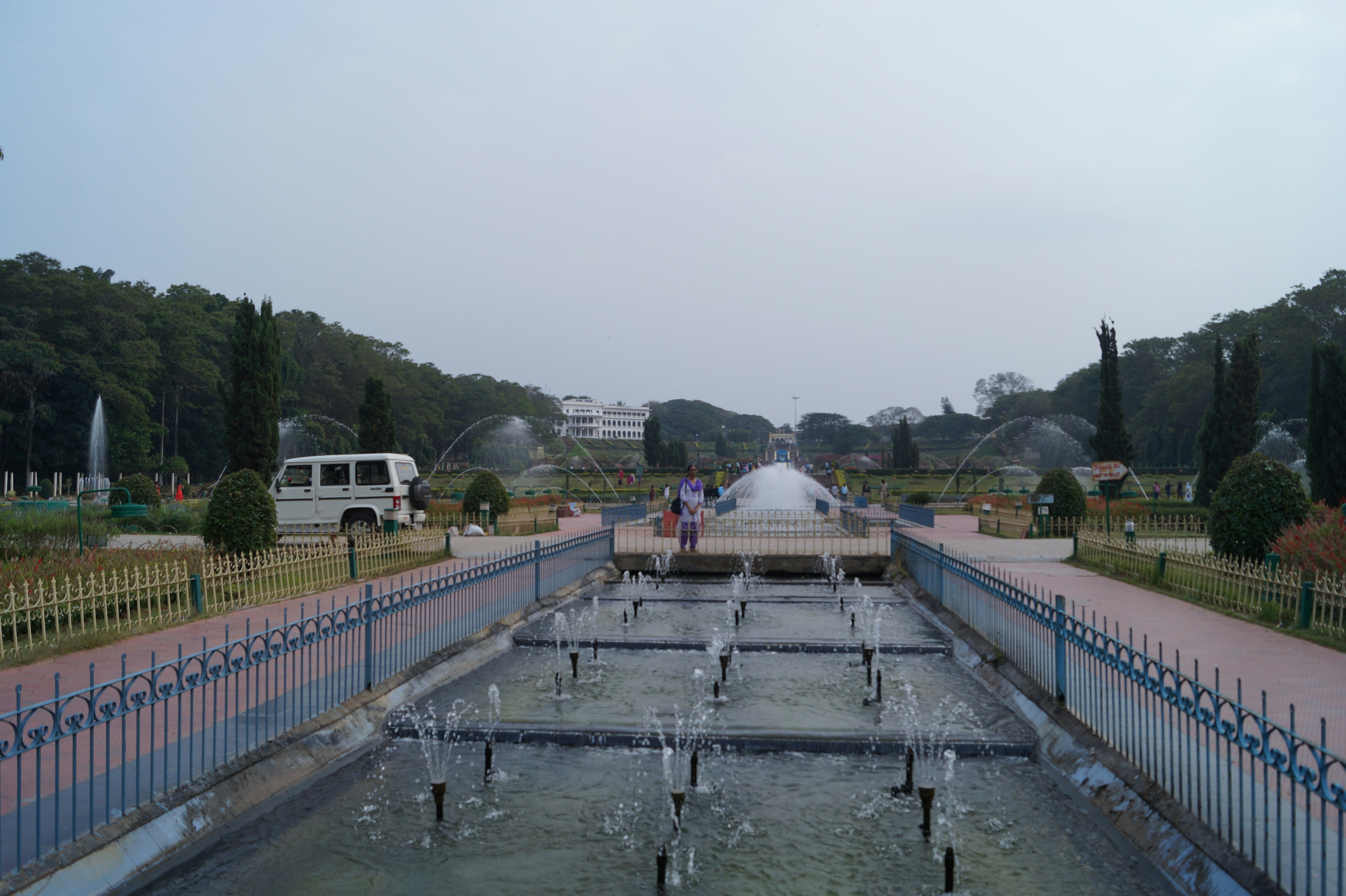 man standing in park with water fountain