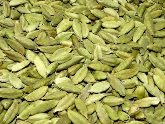 Workers carefully sorting and grading cardamom pods by hand in a clean facility
