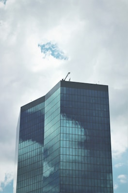 Contemporary luxury building with expansive glass surfaces reflecting a clear sky.
