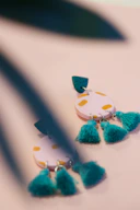 A close-up photo of colorful polymer clay earrings arranged artistically on a wooden surface.
