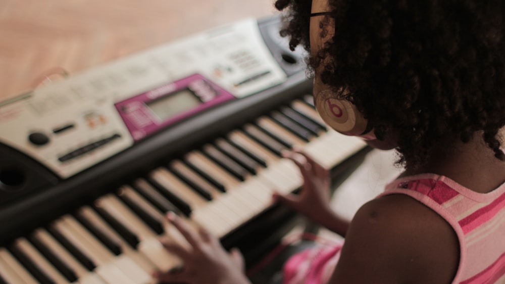 girl playing white and black electronic keyboard