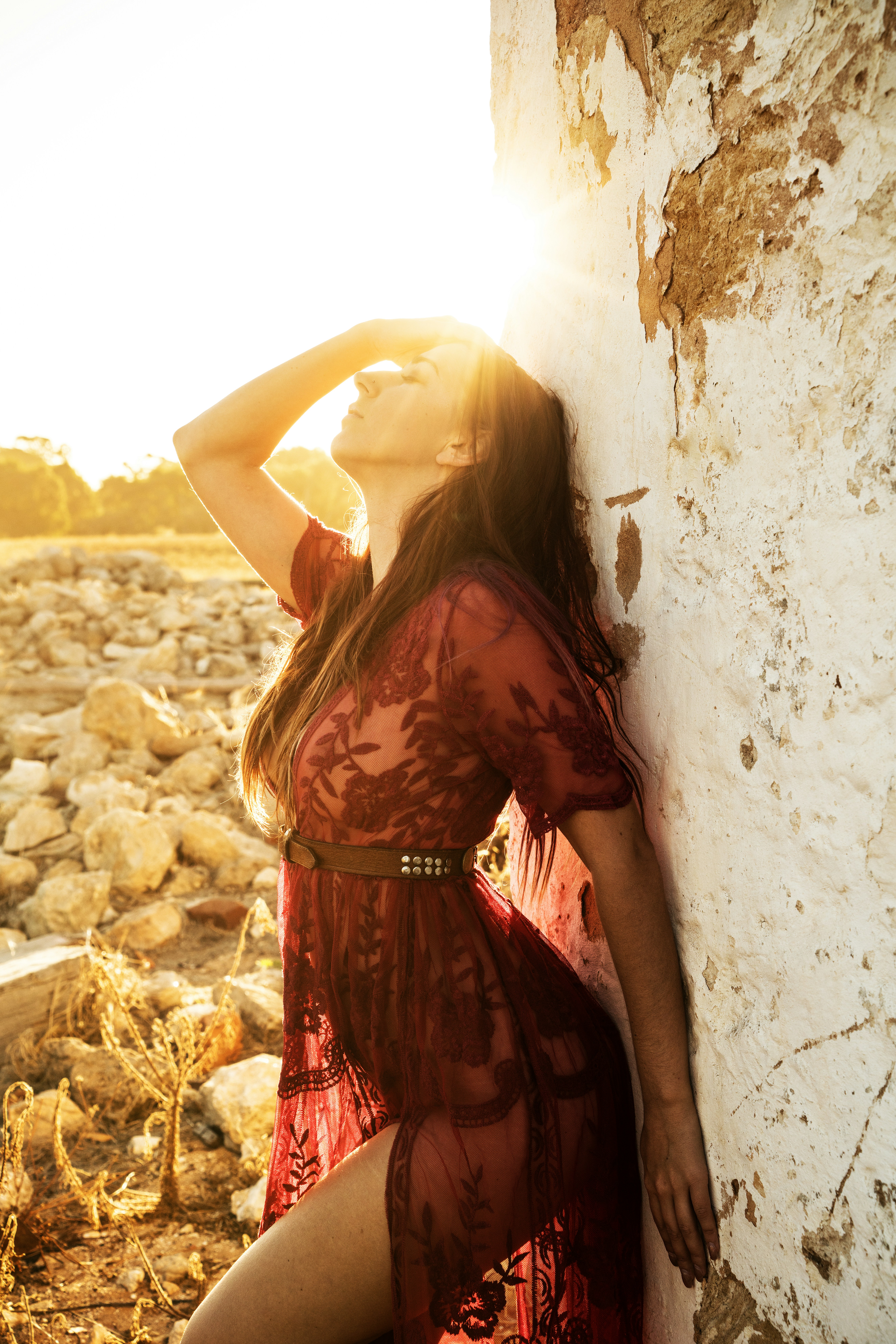 woman leaning on white and brown concrete wall