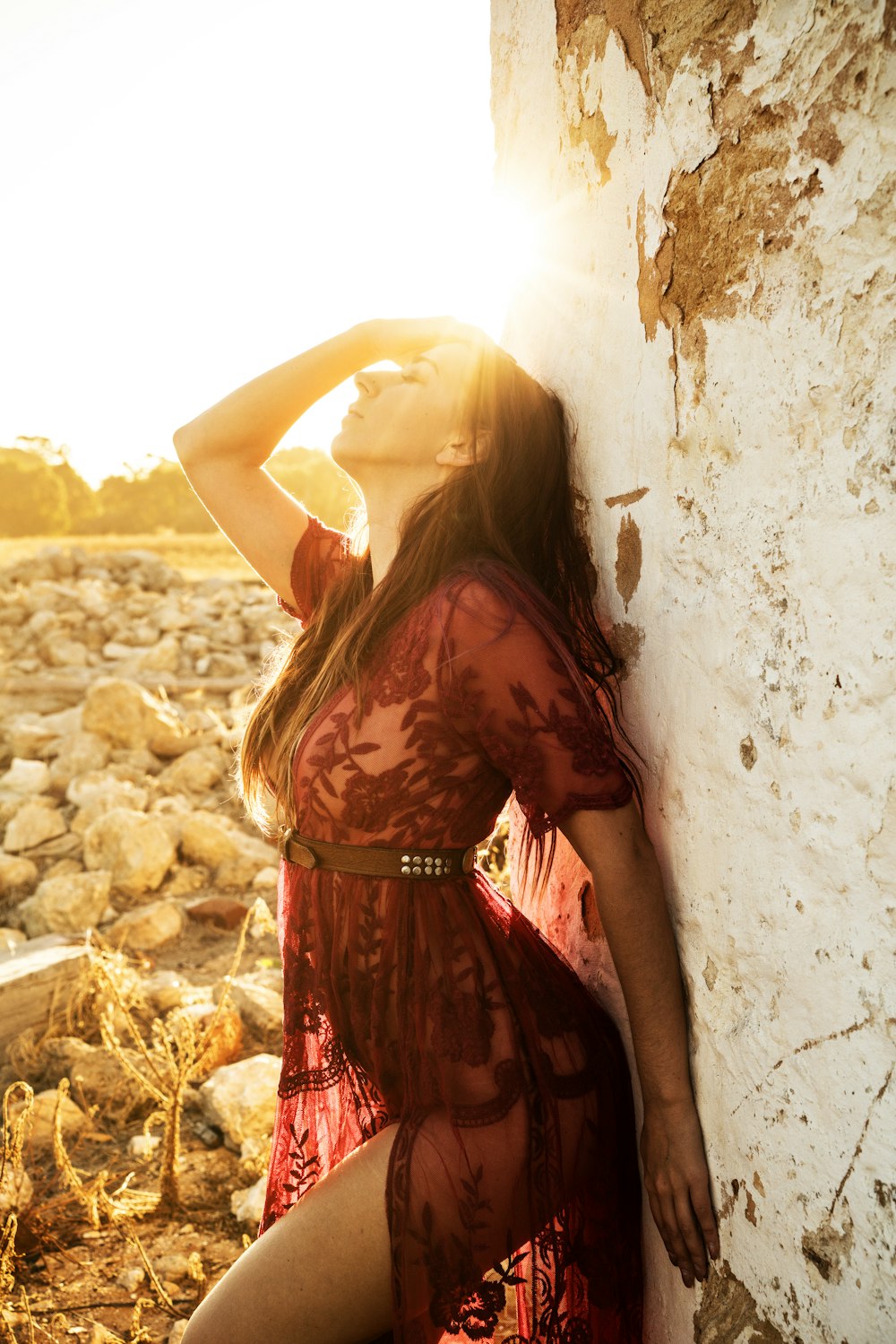 woman leaning on white and brown concrete wall