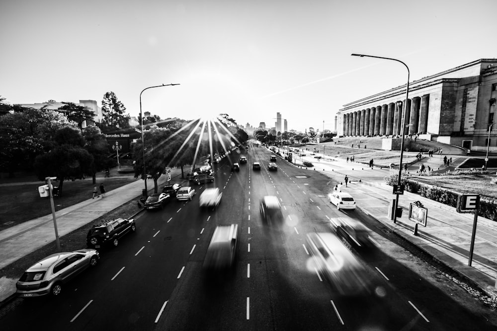grayscale photography of vehicles passing by on road