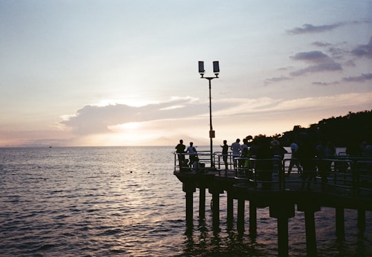 people in dock watching sunset at sea in Lombok Indonesia