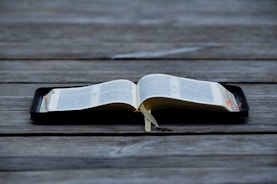 An open book with QR codes visible on the pages, inviting readers to connect with videos and deeper content.