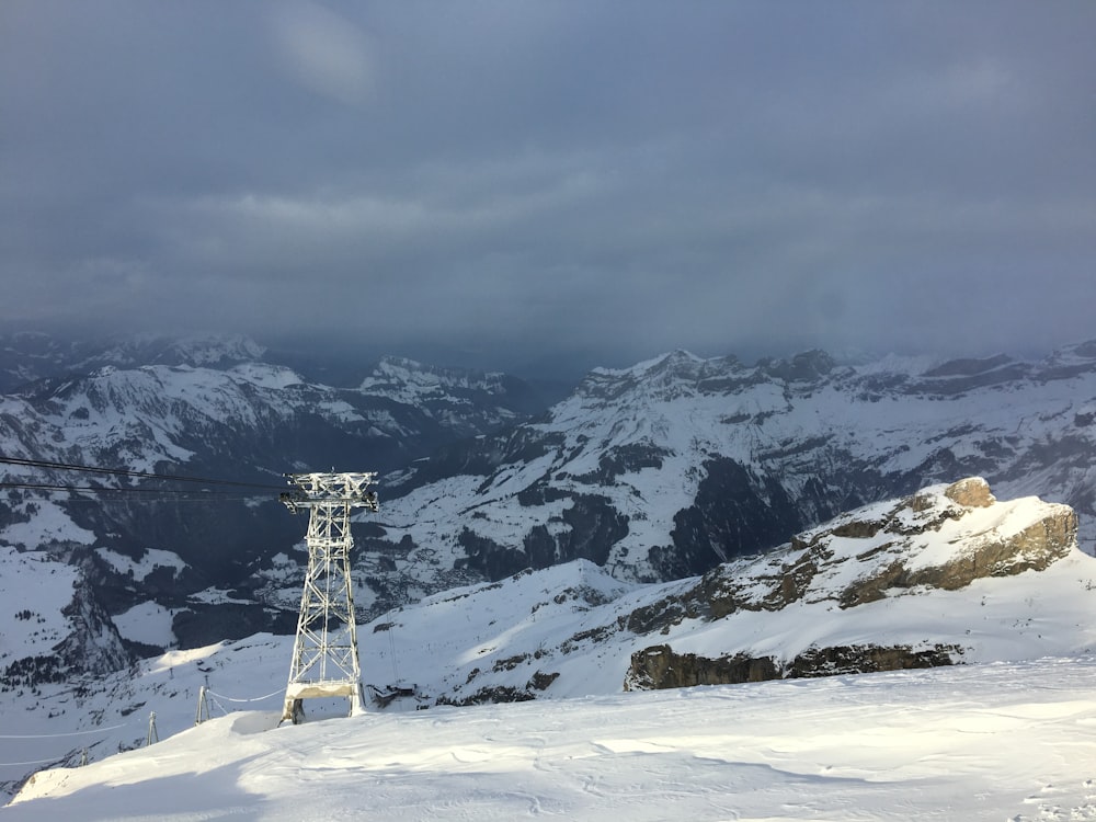 Weißer Stahlturm auf schneebedecktem Hügel