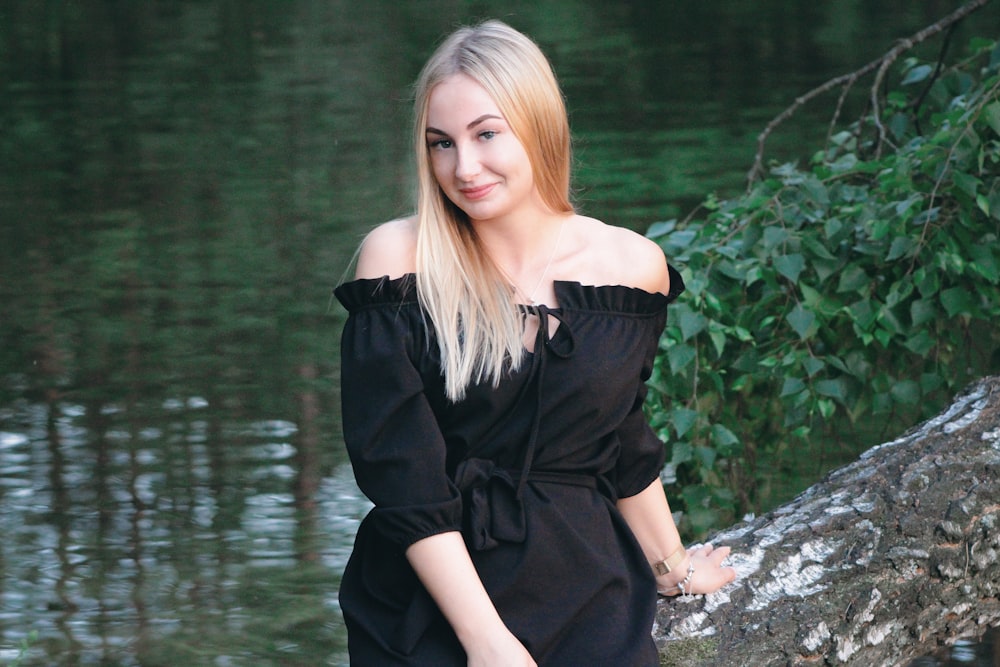 woman sitting on tree trunk