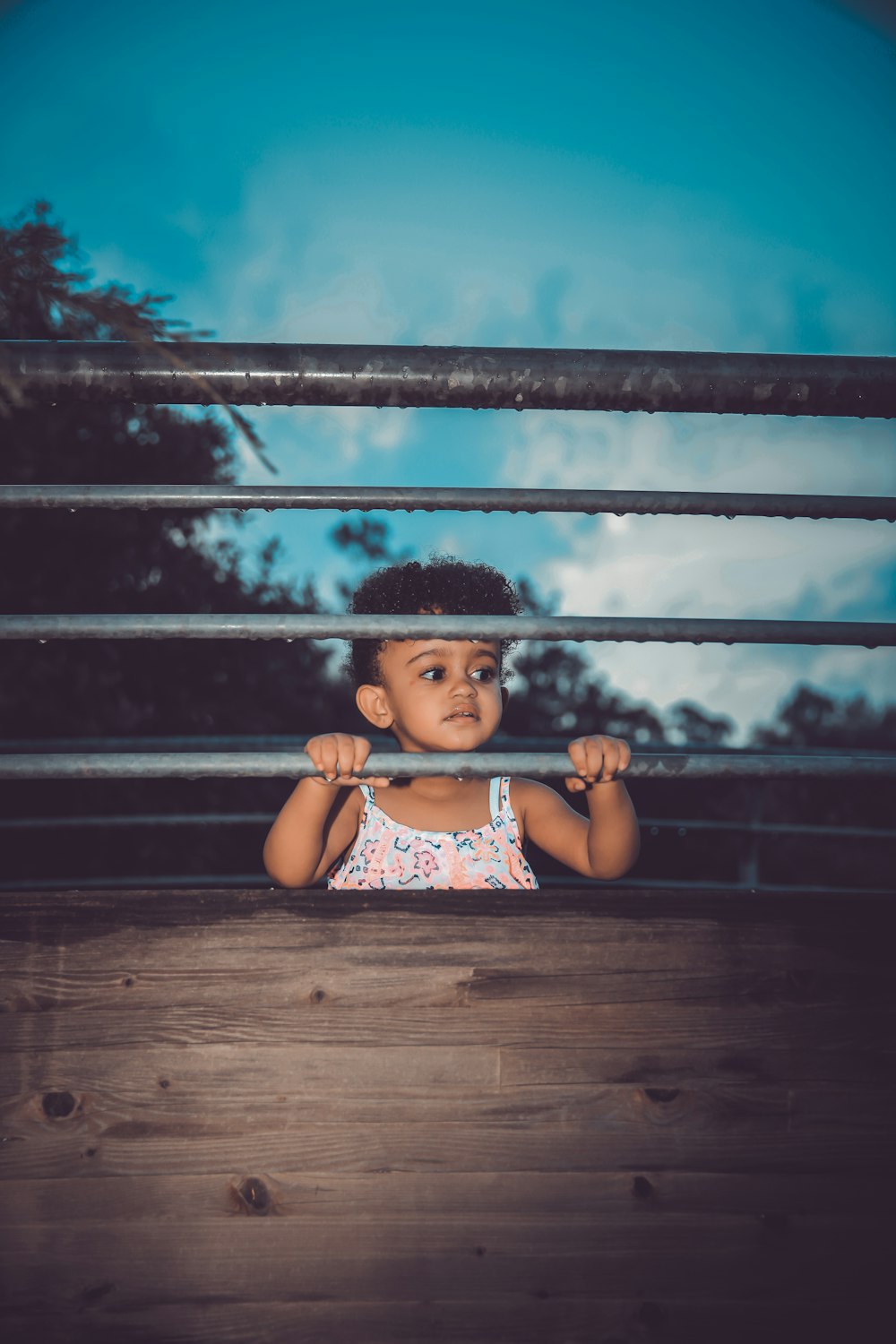 girl standing beside fence