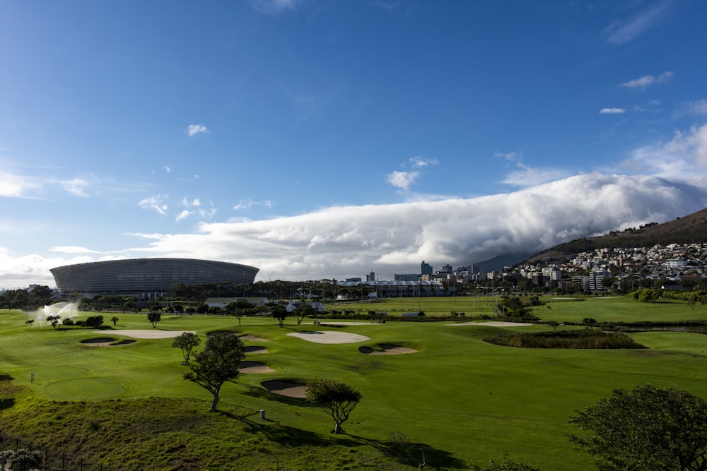 buildings near museum showing green field under blue and white skies