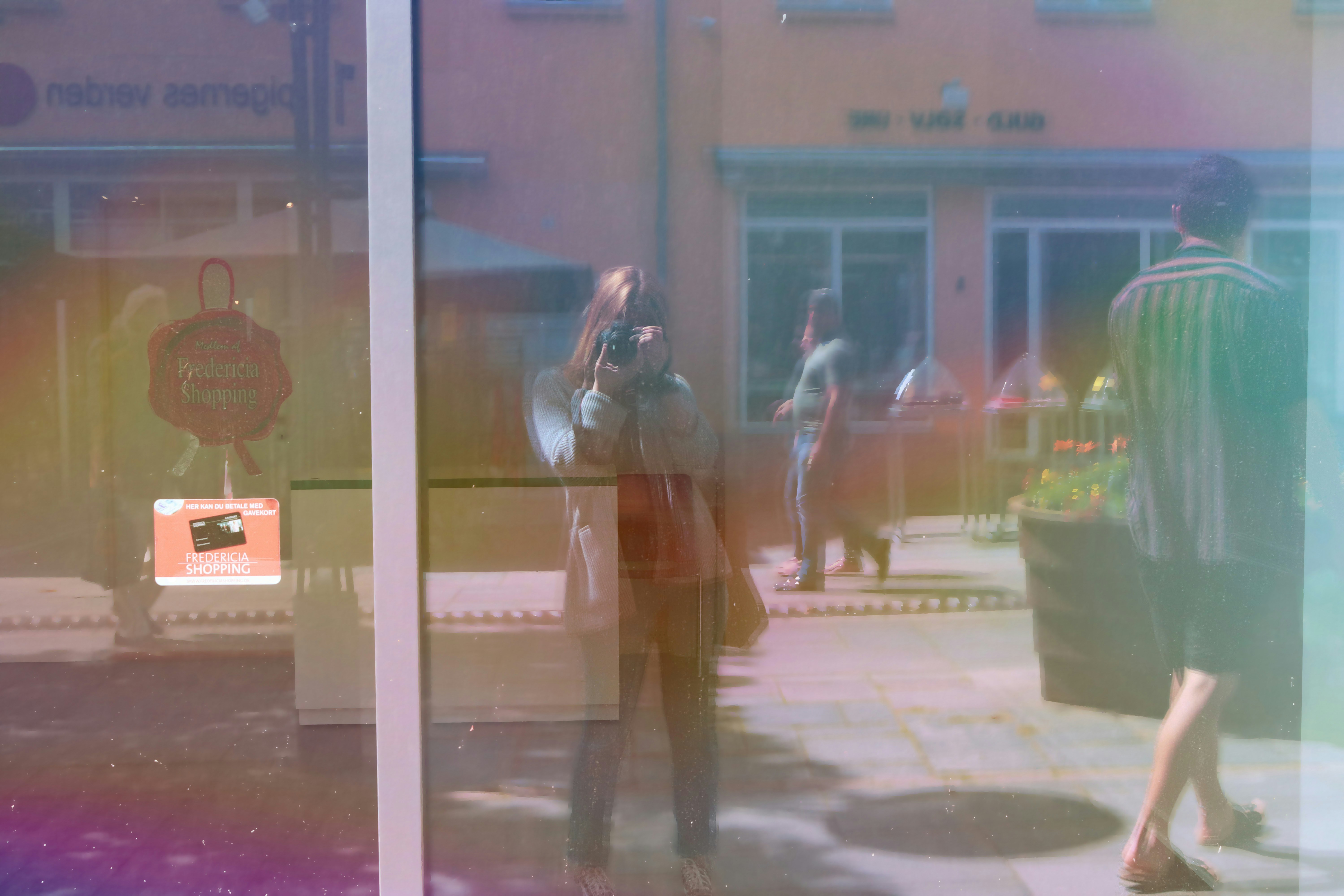 man walking near outdoor passed by woman who takes photo during daytime