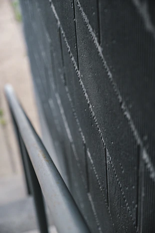 Close-up of a modern dark gray textured wall with subtle silver accents.