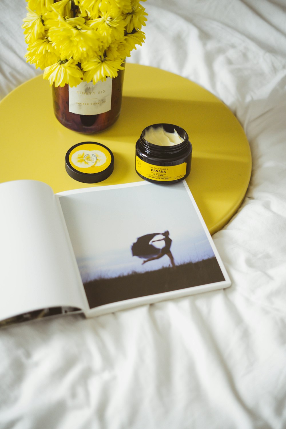 white book and round black container on top of yellow tray