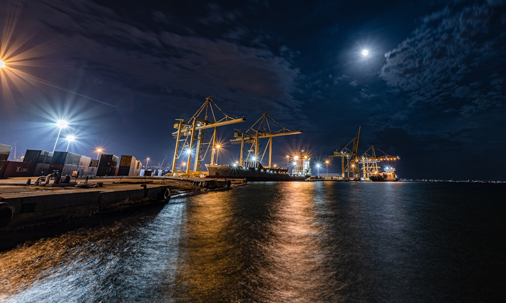 photography of three tower crane during nighttime