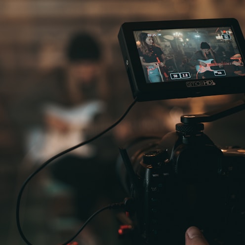 person captures woman playing guitar from the camera