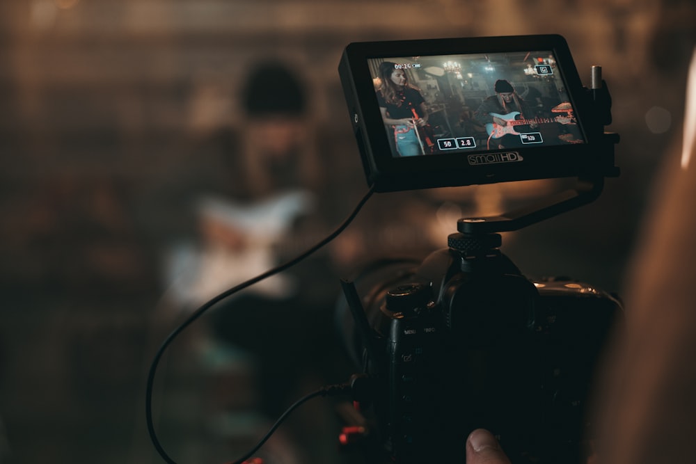 person captures woman playing guitar from the camera