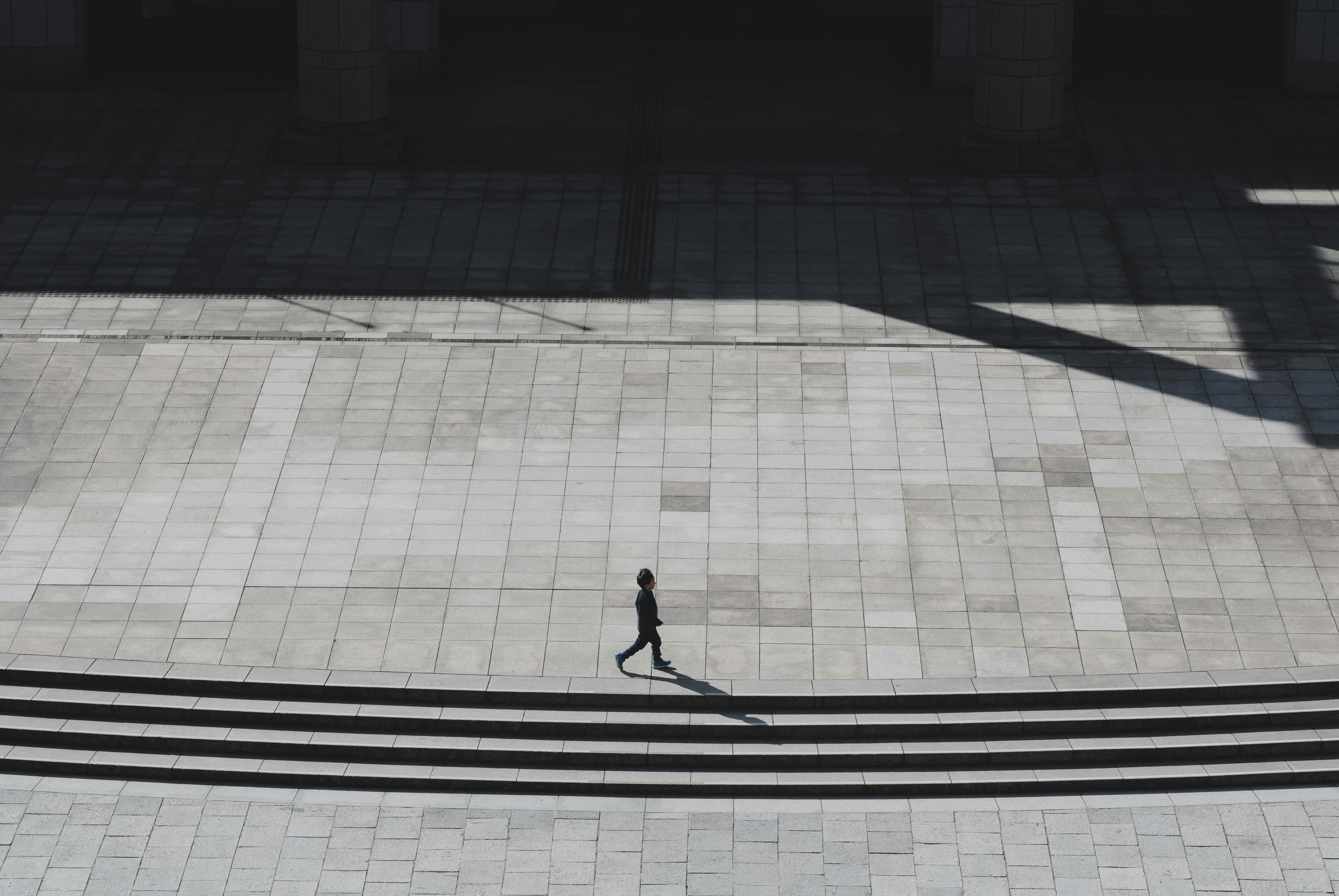 person walking on gray concrete pavement