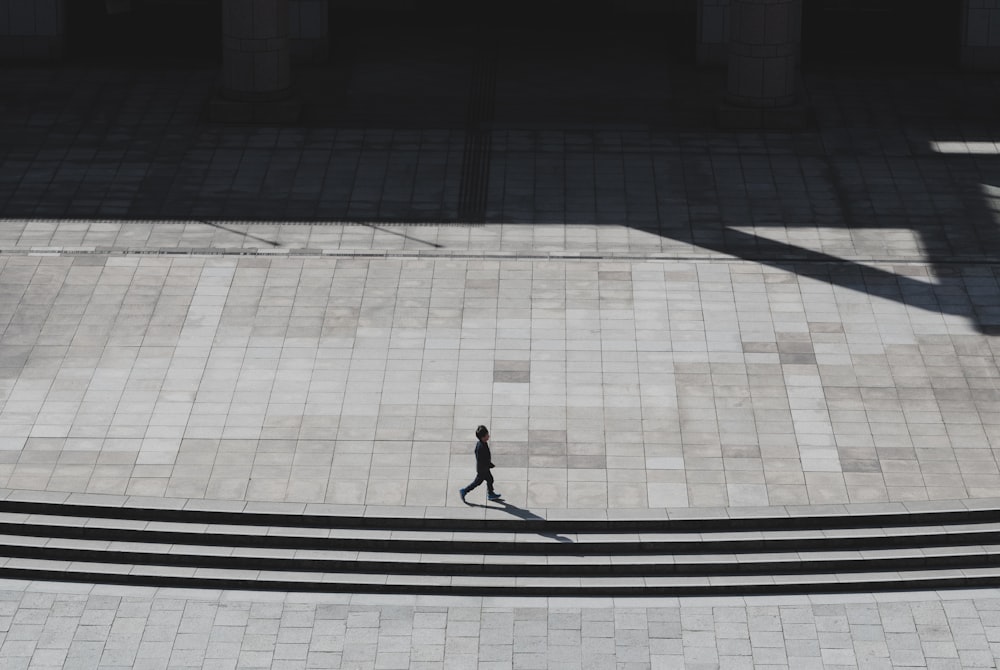 person walking on gray concrete pavement