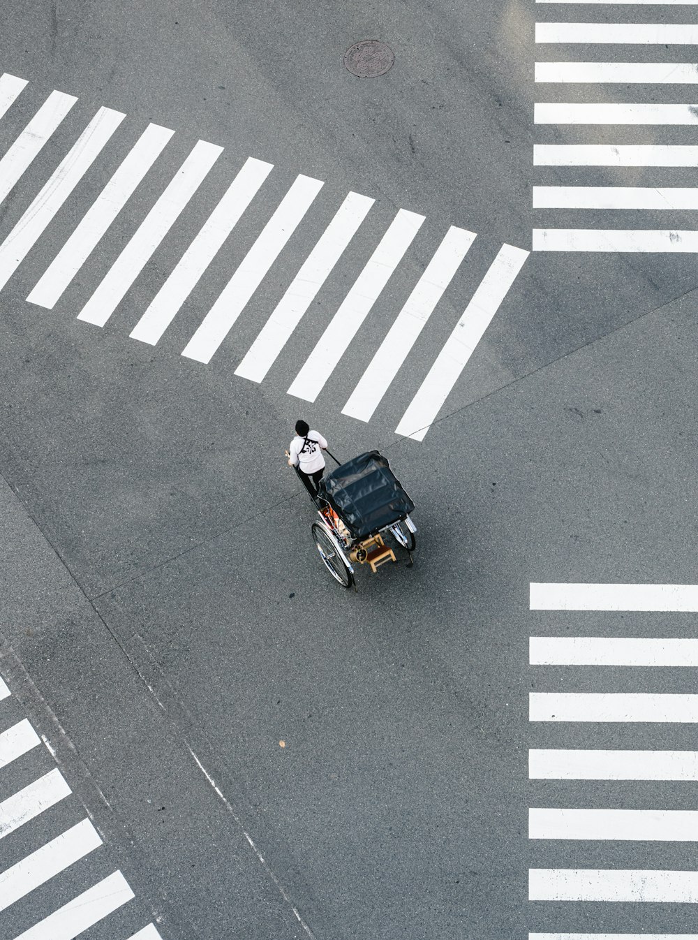man pulling carriage crossing pedestrian