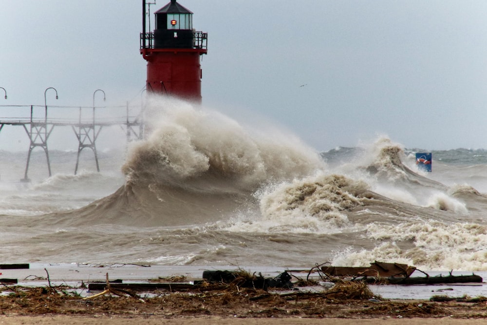 red lighthouse near a body of water during daytime