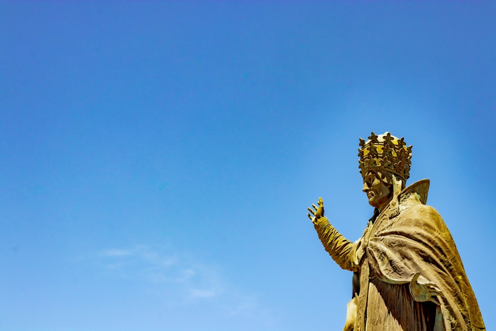 close-up photography of man wearing crown statue