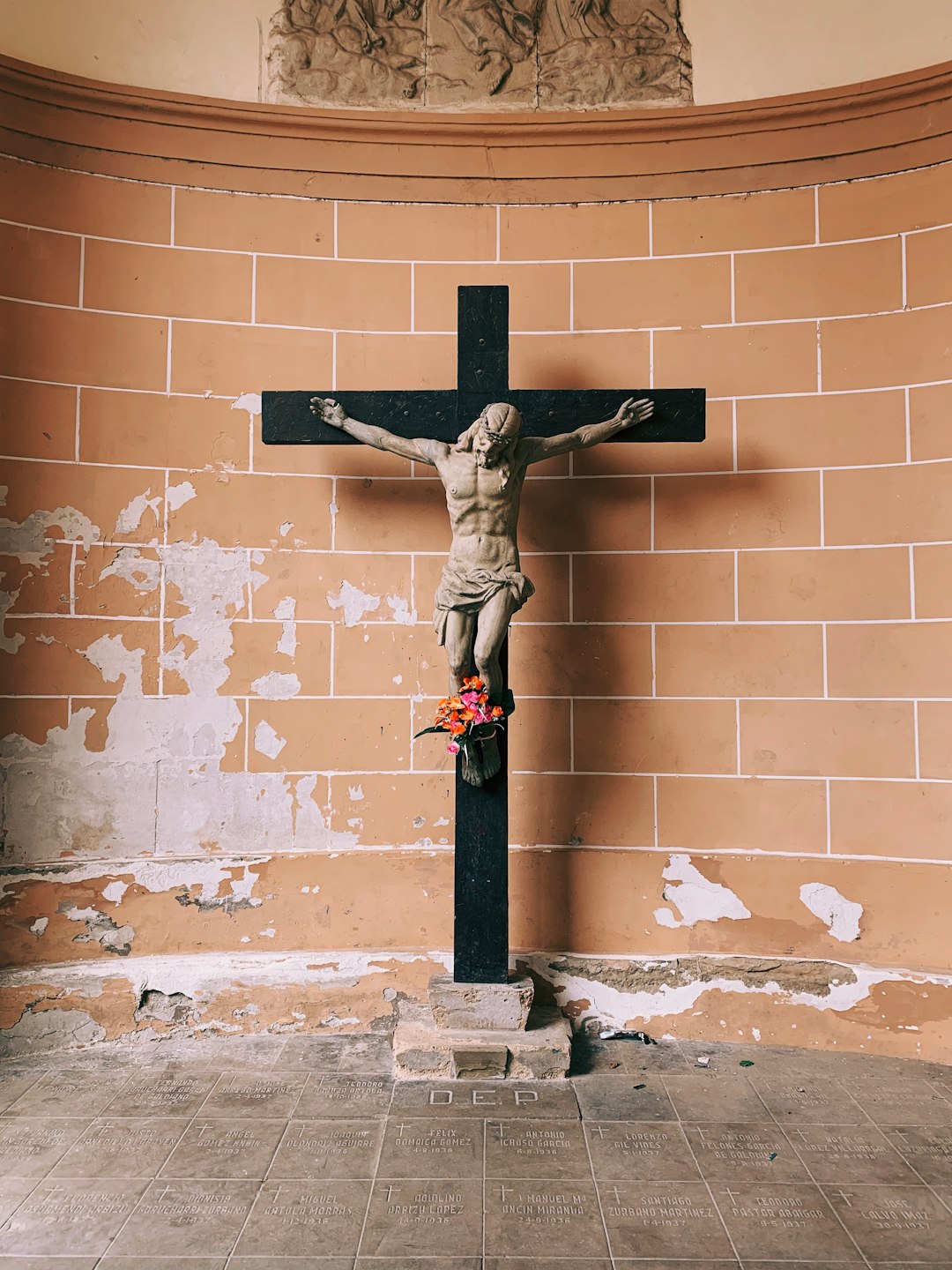 Jesus Christ in a black cross in a brown room close-up photography