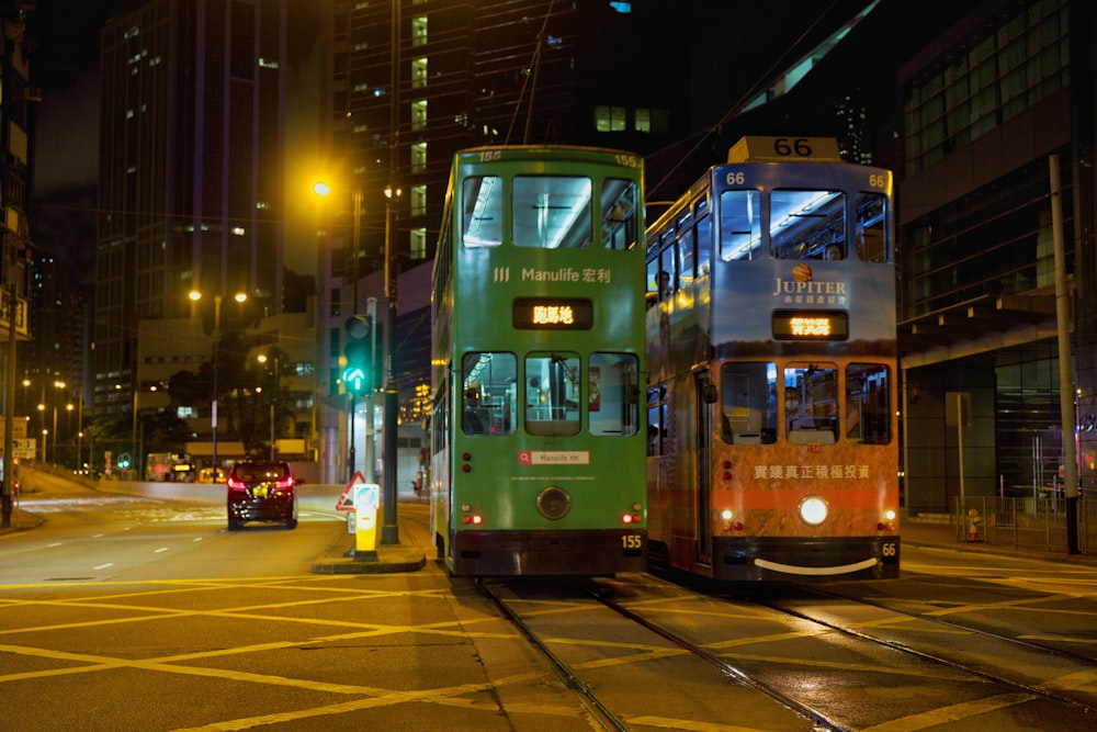 two double decker buses at the street during nighttime
