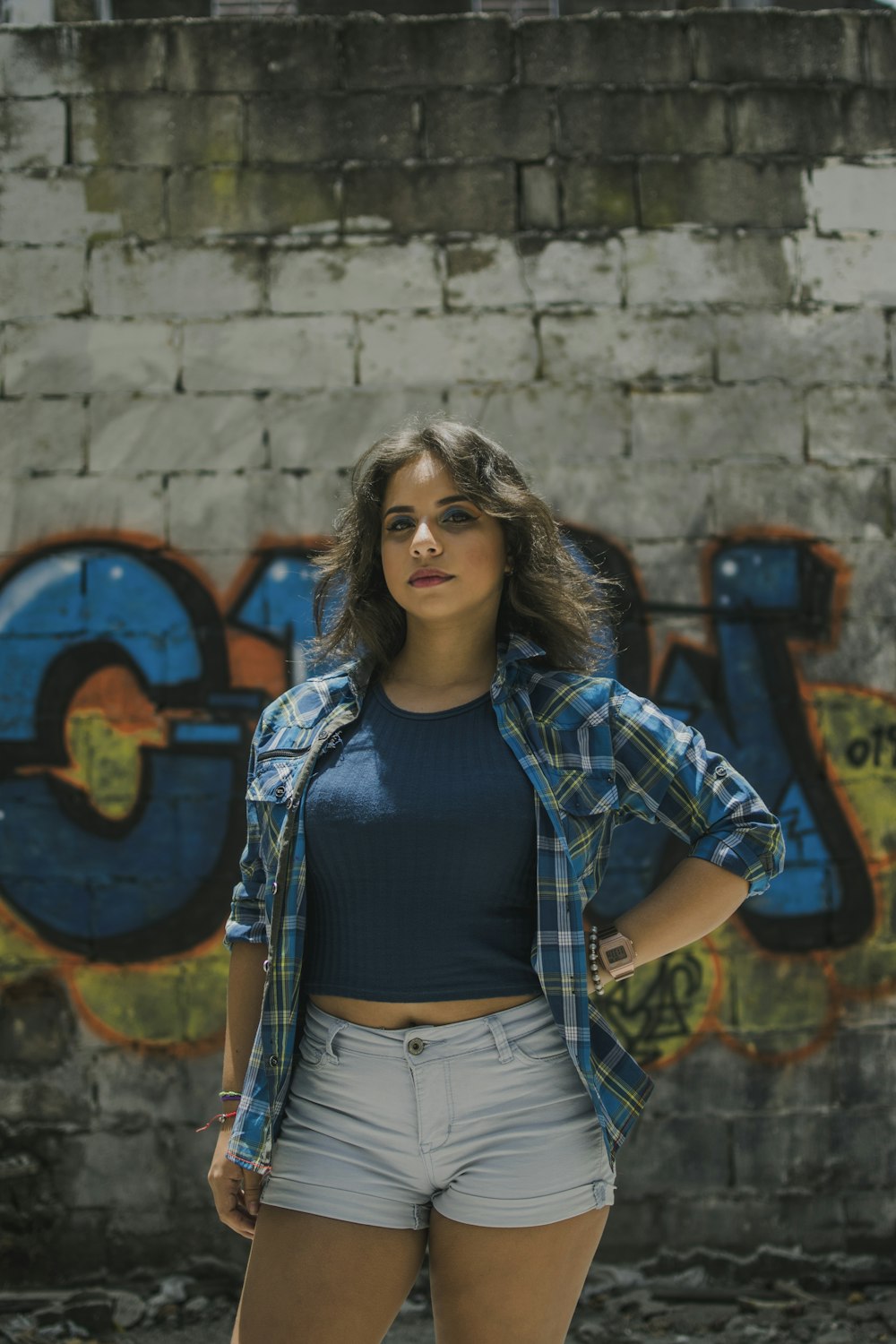 woman standing n front of graffiti painted wall