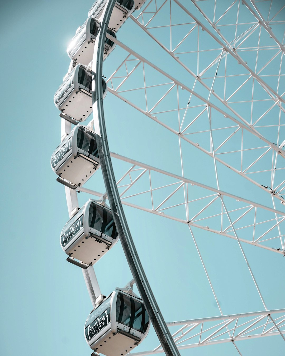 white and grey ferris wheel under clear blue sky