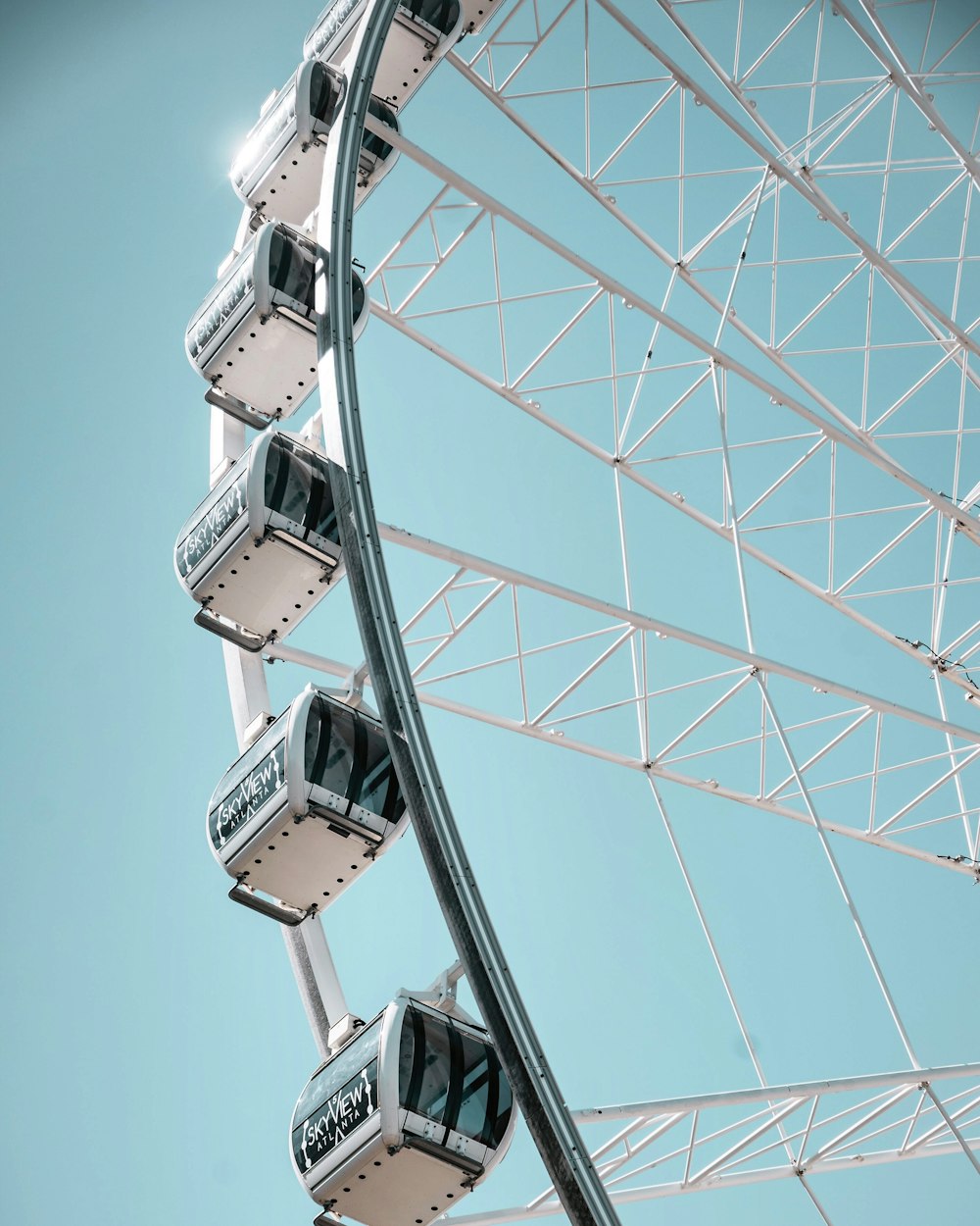 white and grey ferris wheel under clear blue sky