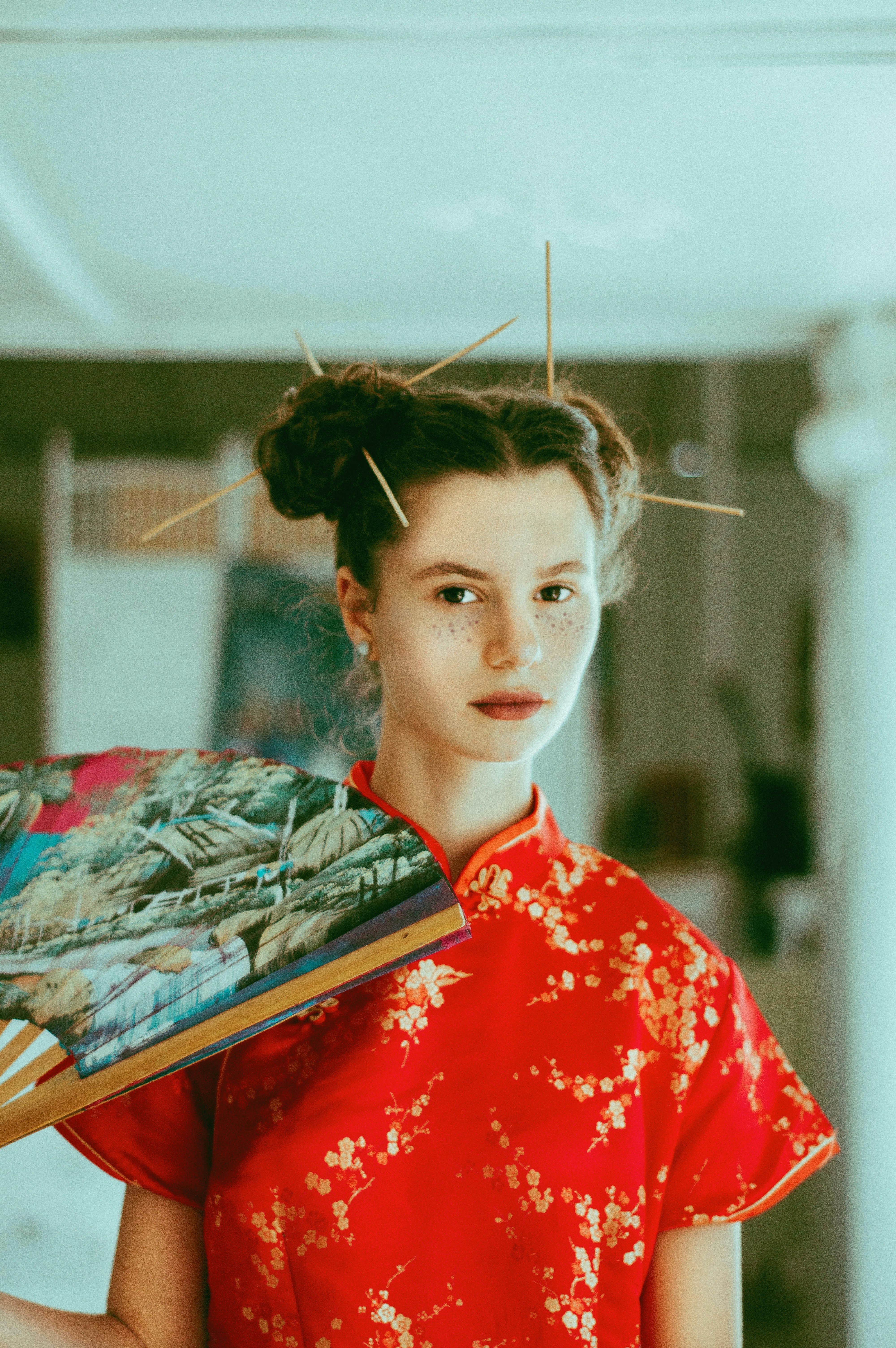 woman holding folding fan inside room