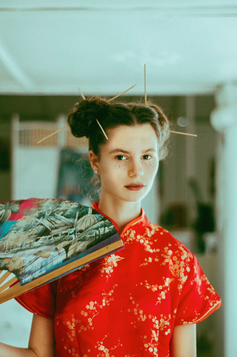 woman holding folding fan inside room