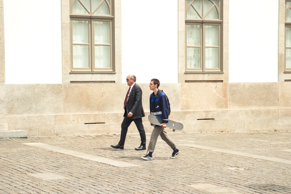 two men walking beside white concrete building