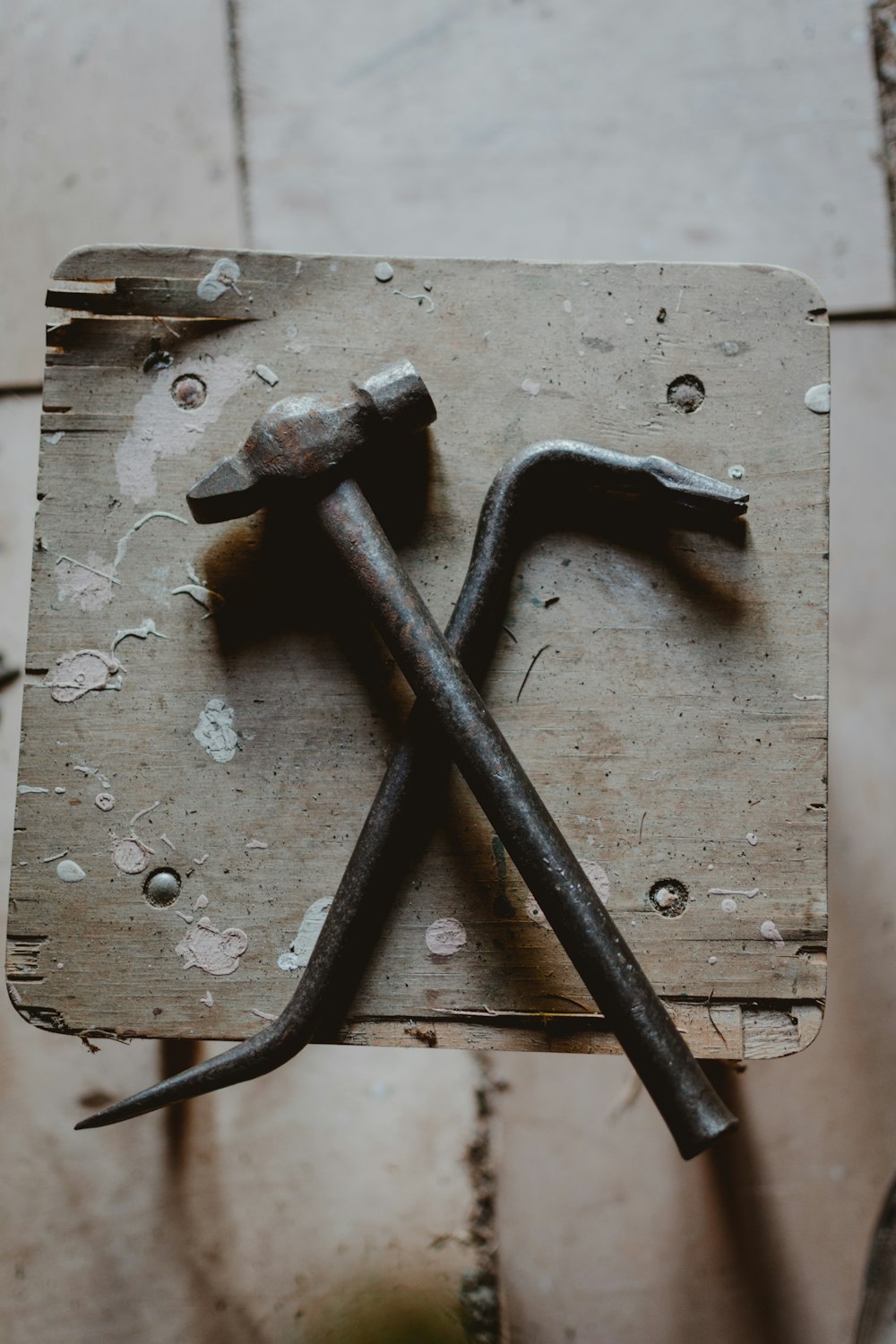 grey ball peen hammer and crow bar on brown wood