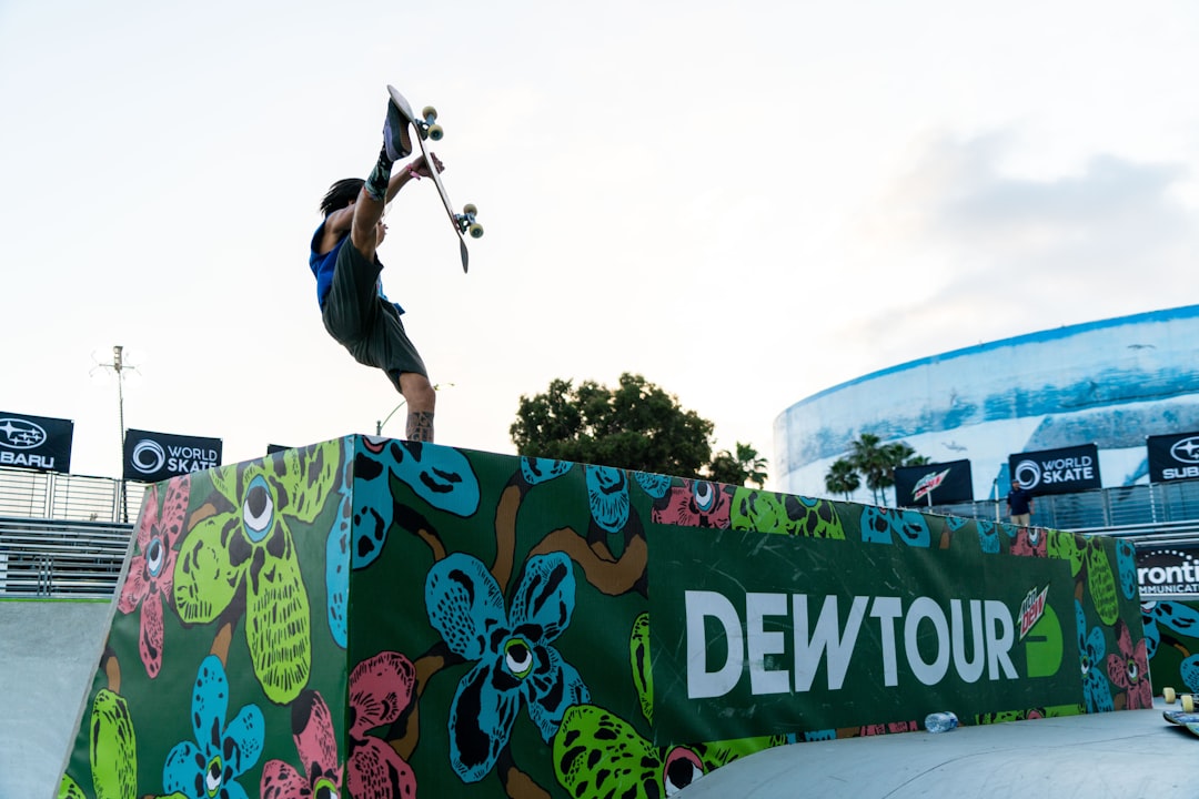 person holding skateboard on Dew Tour platform