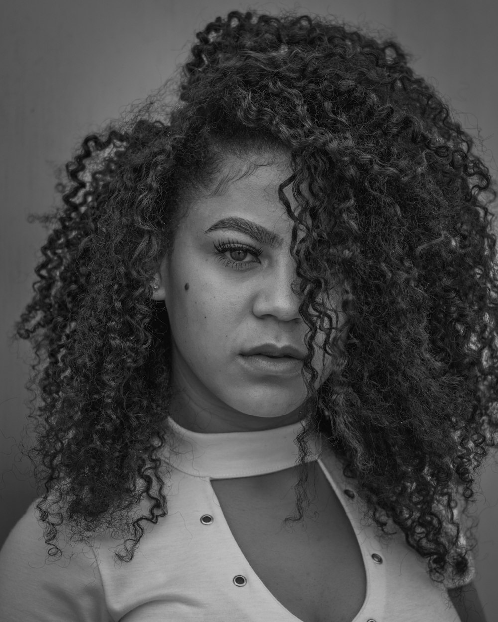 a black and white photo of a woman with curly hair