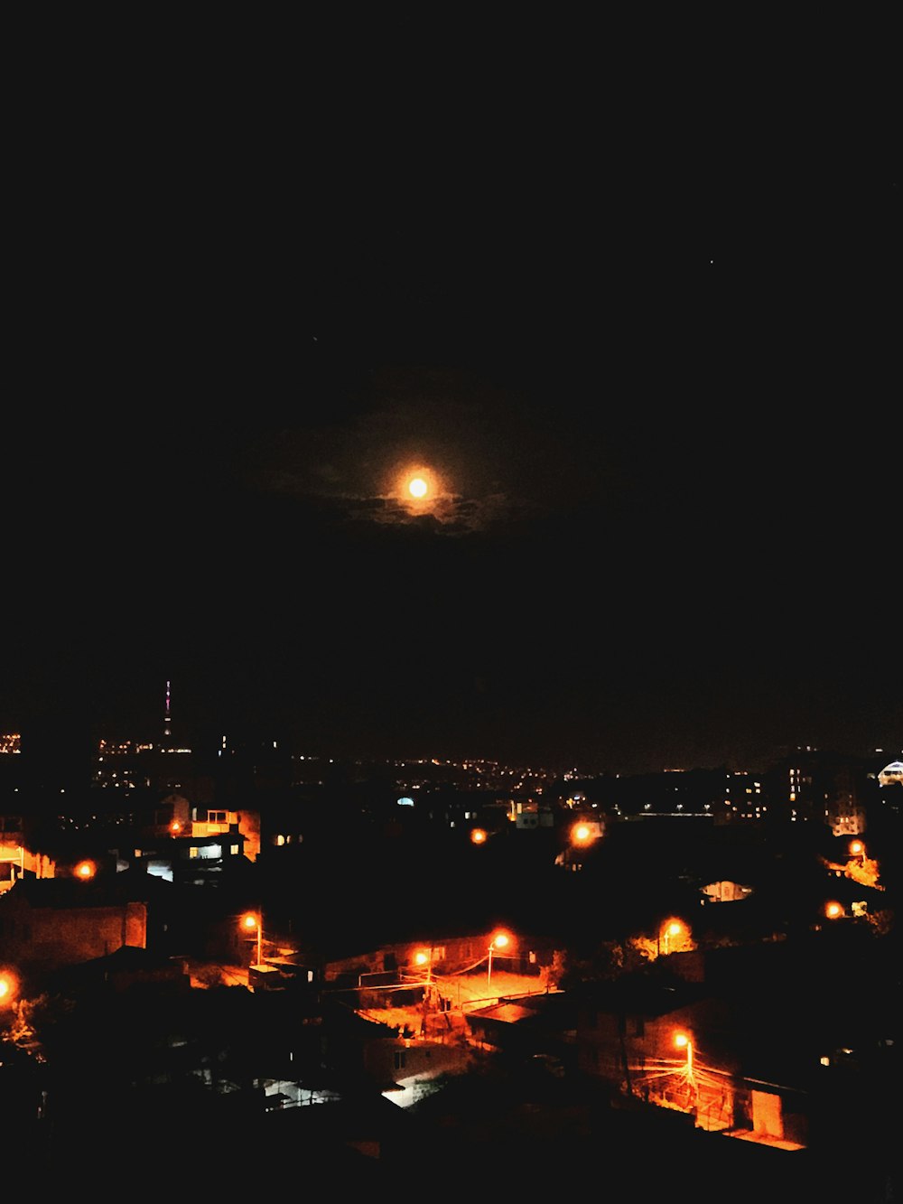 houses during nighttime with light under the moon