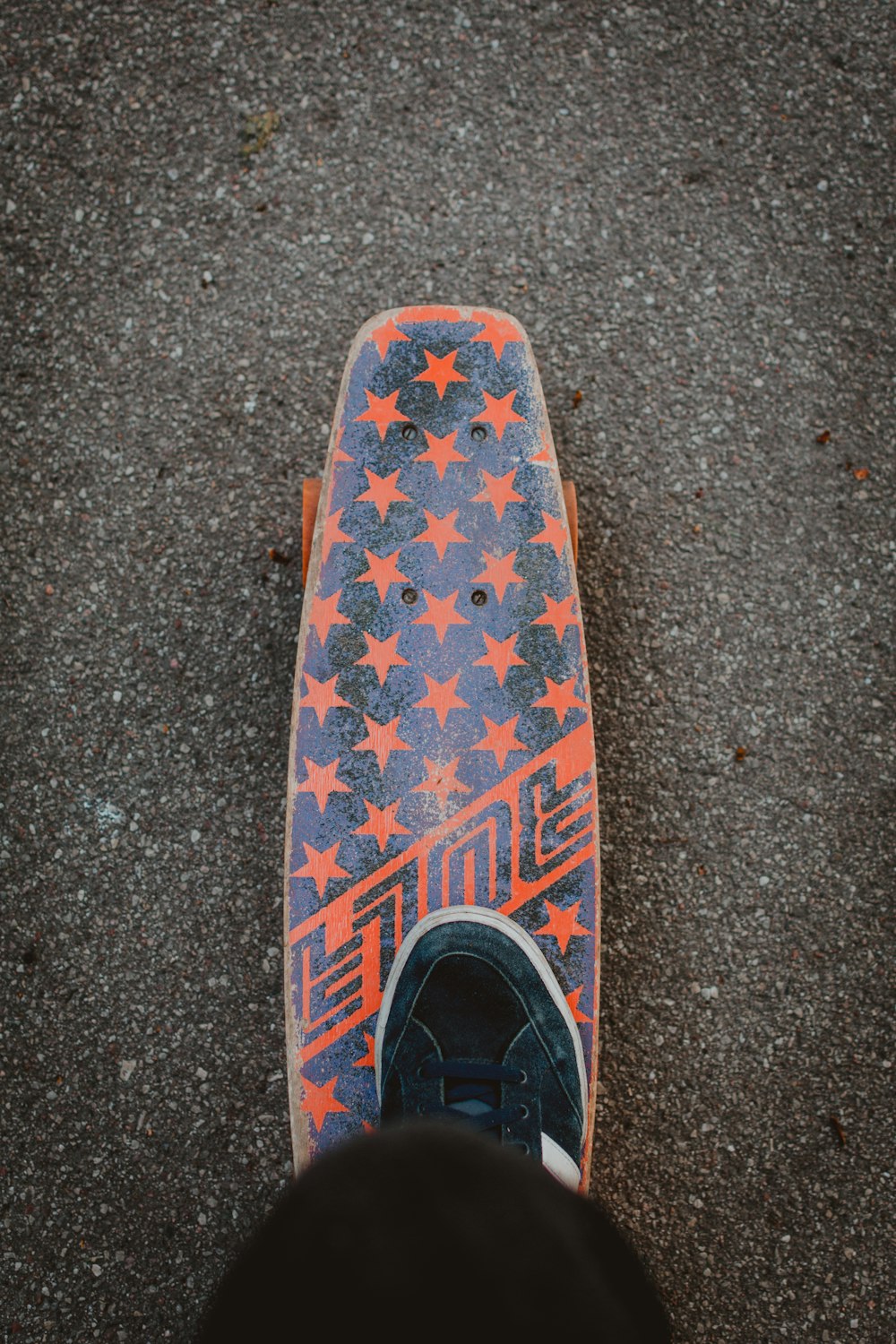 person stepping in a orange skate board close-up photography