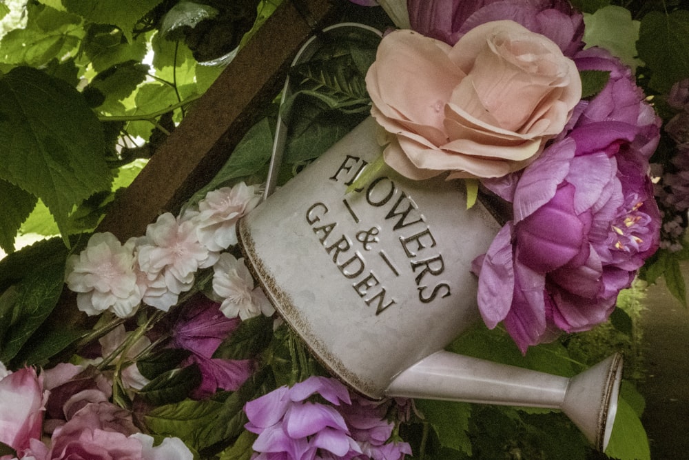 pink and orange flowers on grey watering can