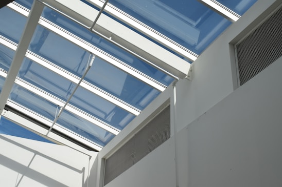 A bright, modern room featuring a white PVC ceiling and a clear PVC skylight letting in natural light.
