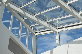 a white building with a glass roof and sky in the background